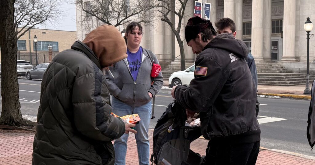 Outreach team connecting with individuals on a city sidewalk.